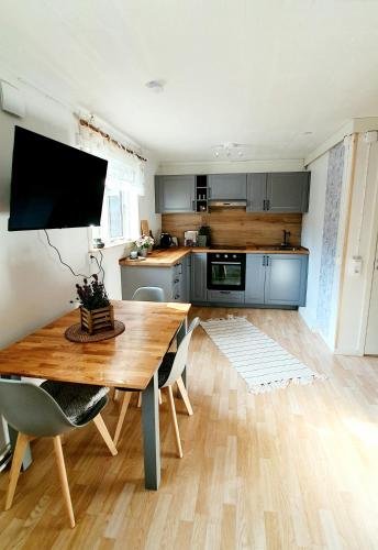 a kitchen with a wooden table and a dining room at Stationshuset Dalarna Apartments in Sörsjön