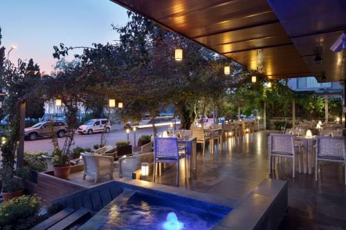 een restaurant met tafels en stoelen en een vijver bij DoubleTree by Hilton Kusadasi in Kuşadası