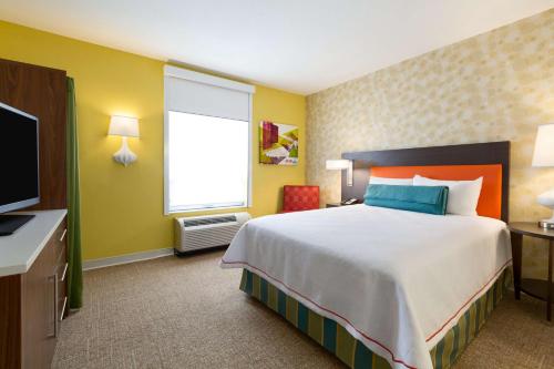 a hotel room with a large bed and a television at Home2 Suites by Hilton West Edmonton in Edmonton