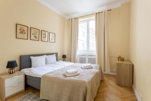 1 dormitorio con 1 cama con 2 toallas en Golden Apartments Warsaw- 3 Separate Rooms Sleep 7 - Best Location&Nowy Świat, en Varsovia