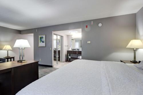 a hotel room with a bed and a living room at Hampton Inn & Suites by Hilton Brantford in Brantford