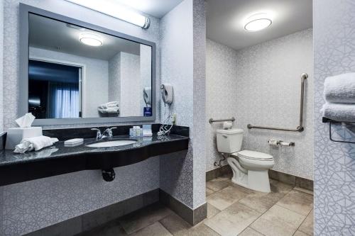 a bathroom with a sink and a toilet and a mirror at Hampton Inn & Suites by Hilton Brantford in Brantford