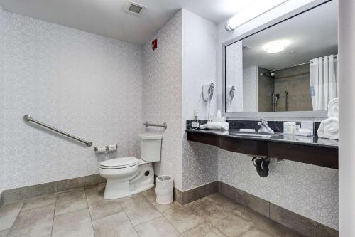 a bathroom with a toilet and a sink and a mirror at Hampton Inn & Suites by Hilton Brantford in Brantford
