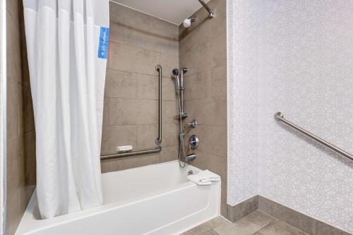 a bathroom with a tub and a shower with a shower curtain at Hampton Inn & Suites by Hilton Brantford in Brantford