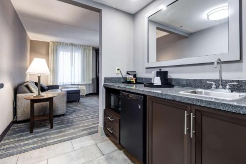 a hotel room with a sink and a living room at Hampton Inn & Suites by Hilton Brantford in Brantford