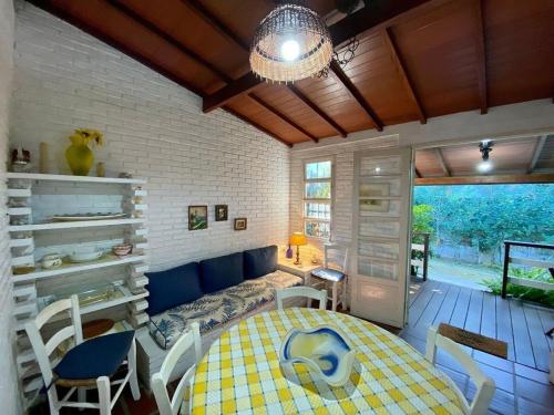 uma sala com uma mesa, cadeiras e um sofá em Villa do Aconchego em Ubatuba
