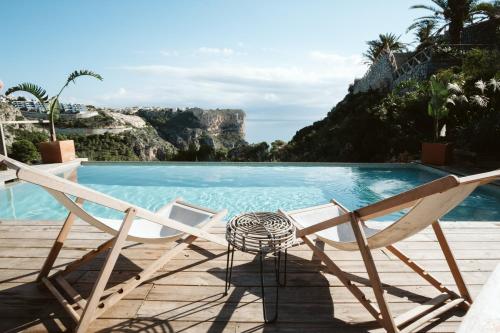 une paire de chaises assises à côté de la piscine dans l'établissement Dreamsea Mediterranean Camp, à Benitachell