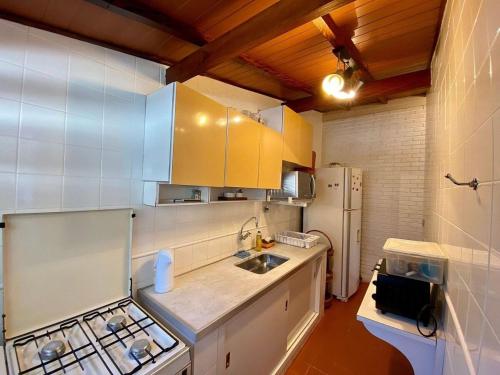 uma cozinha com pia e geladeira em Villa do Aconchego em Ubatuba