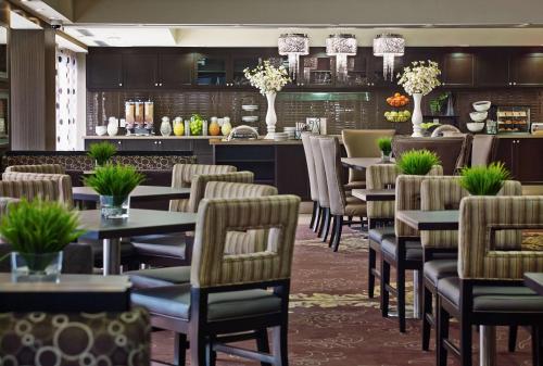 a restaurant with tables and chairs and a bar at Homewood Suites by Hilton Hamilton in Hamilton