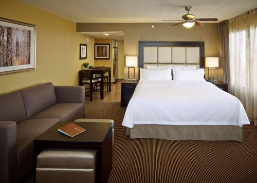 a hotel room with a large bed and a couch at Homewood Suites by Hilton Hamilton in Hamilton