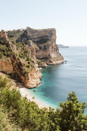 a beach on the side of a cliff at Dreamsea Mediterranean Camp in Benitachell