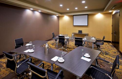 a conference room with tables and chairs and a screen at Homewood Suites by Hilton Hamilton in Hamilton