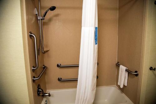 a bathroom with a shower and a white shower curtain at Hampton Inn & Suites Sharon in West Middlesex