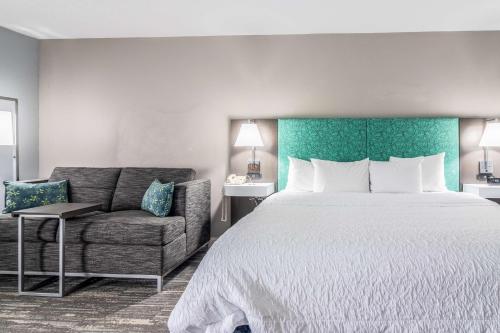 a hotel room with a bed and a couch at Hampton Inn Youngstown-North in Youngstown