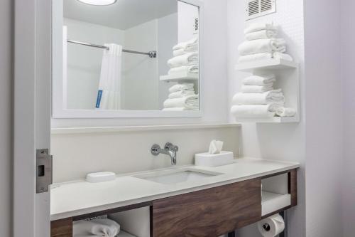 a bathroom with a sink and a mirror and towels at Hampton Inn Youngstown-North in Youngstown