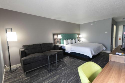 a hotel room with a bed and a couch at Hampton Inn Youngstown-North in Youngstown
