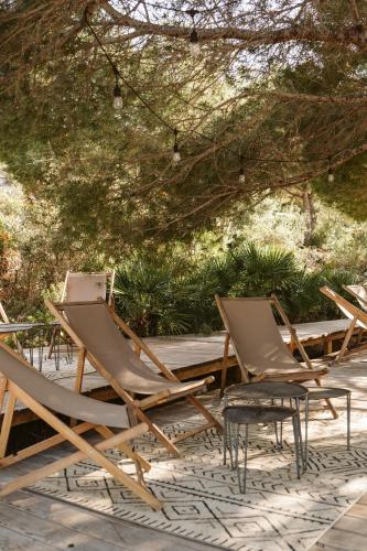 a group of lawn chairs sitting under a tree at Dreamsea Mediterranean Camp in Benitachell