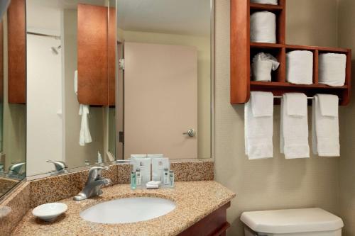 a bathroom with a sink and a toilet and a mirror at Hampton Inn - York in York