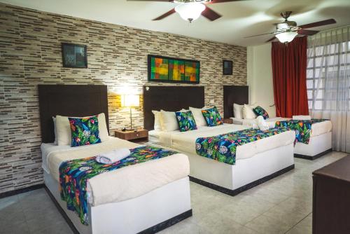 a bedroom with three beds and two couches at Villeta Boutique Hotel Spa in Villeta