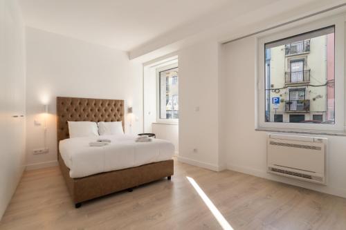 una camera bianca con un grande letto e una finestra di City Stays São Lázaro Apartments a Lisbona