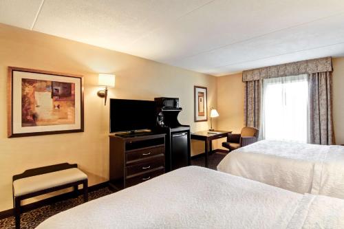 a hotel room with two beds and a television at Hampton Inn Sudbury, Ontario in Sudbury