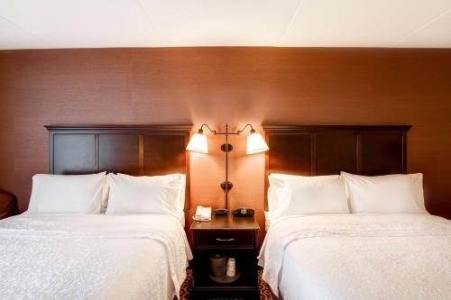 two beds in a hotel room with white sheets at Hampton Inn Sudbury, Ontario in Sudbury