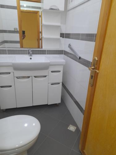 a bathroom with a toilet and a sink and a mirror at Ajdir in Al Hoceïma
