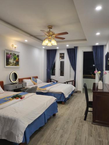 a hotel room with three beds and a ceiling fan at Huong Mai Hotel in Da Lat