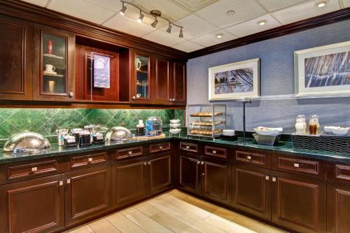 a large kitchen with wooden cabinets and counters at Homewood Suites by Hilton Toronto Mississauga in Mississauga