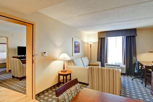 a hotel room with a couch and a table at Homewood Suites by Hilton Toronto Mississauga in Mississauga