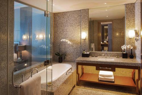 a bathroom with a tub and a sink and a shower at InterContinental Hanoi Landmark72 by IHG in Hanoi