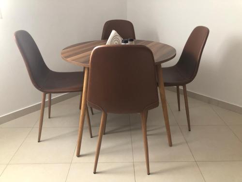 a wooden table with three chairs around it at Artemis House in Artemida