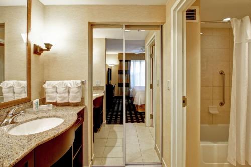 a hotel bathroom with a sink and a shower at Homewood Suites by Hilton Toronto Airport Corporate Centre in Toronto
