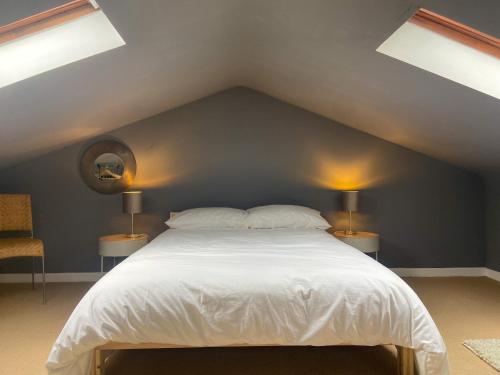 a bedroom with a large white bed with two lamps at Sunset Cottage in Kenmare