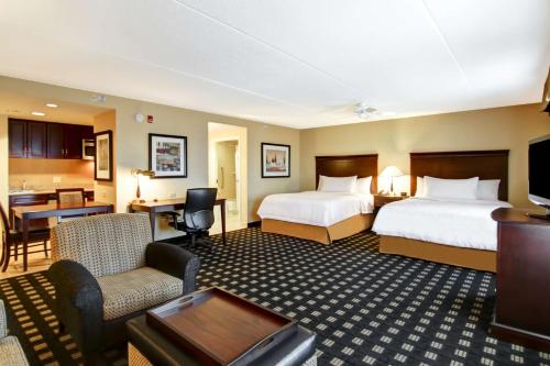 Habitación de hotel con 2 camas y sala de estar. en Homewood Suites by Hilton Toronto Airport Corporate Centre, en Toronto