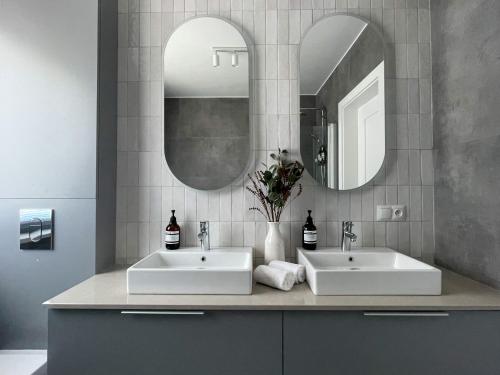 due lavandini in un bagno con due specchi di Dom na Wiklinowej a Dobrzewino