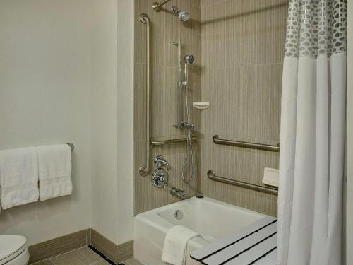 a bathroom with a shower and a tub and a toilet at Hampton Inn by Hilton Winnipeg in Winnipeg