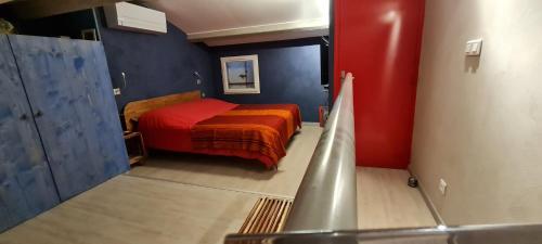 - une petite chambre avec un lit dans une pièce aux murs rouges dans l'établissement Charmante maison à 4min de plage du débarquement, à La Croix-Valmer