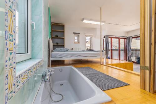 a bath tub in a room with a bed at Center PENTHOUSE apartment - HUGE TERRACE and FREE PARKING - Tram/Metro - AC in Budapest