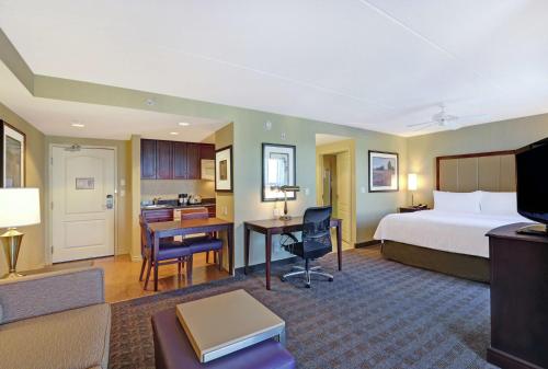 ケンブリッジにあるHomewood Suites by Hilton Cambridge-Waterloo, Ontarioのベッドとデスクが備わるホテルルームです。