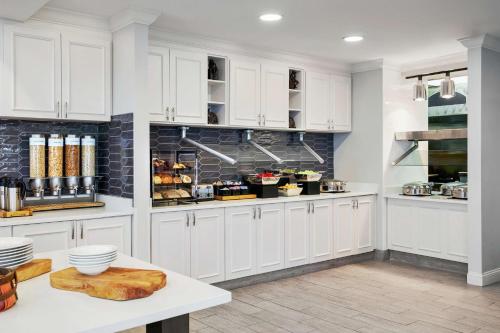 a kitchen with white cabinets and a white counter top at Hilton Garden Inn Allentown West in Breinigsville