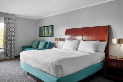 a bedroom with a large bed and a blue chair at Hilton Garden Inn Allentown West in Breinigsville