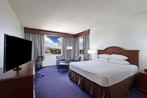 um quarto de hotel com uma cama e uma televisão de ecrã plano em Hilton Waco em Waco