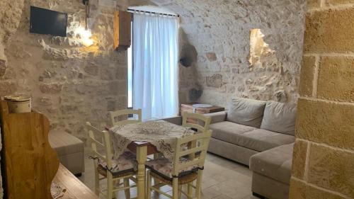 un soggiorno con tavolo e divano di Casa vacanza Appia Antica a Carovigno