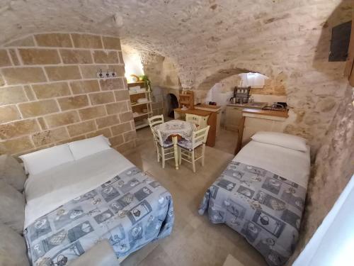 una camera con due letti e un muro di pietra di Casa vacanza Appia Antica a Carovigno