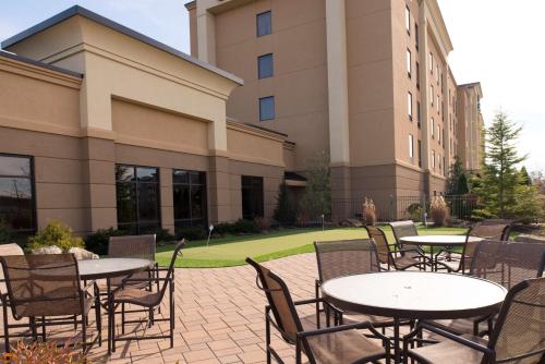 a patio with tables and chairs in front of a building at Hampton Inn & Suites Vineland in Vineland