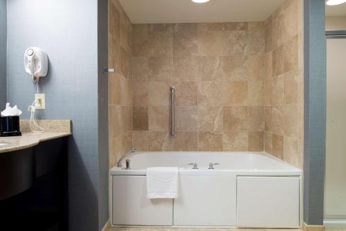 a bathroom with a white tub and a sink at Hampton Inn & Suites Vineland in Vineland