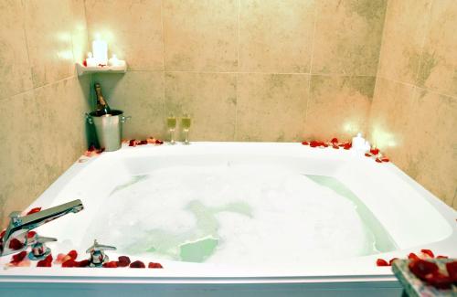 una vasca da bagno con bacche rosse intorno di DoubleTree by Hilton Augusta ad Augusta