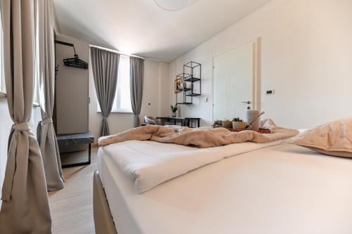 a white bedroom with two beds and a window at Villa Hresc M in Zadar