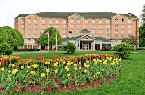 a building with a bunch of flowers in front of it at Hilton Garden Inn Albany Airport in Albany
